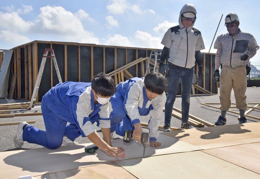 お化け屋敷の屋根を組み立てる生徒ら。慣れない現場作業に四苦八苦（南国市の吾岡山文化の森）