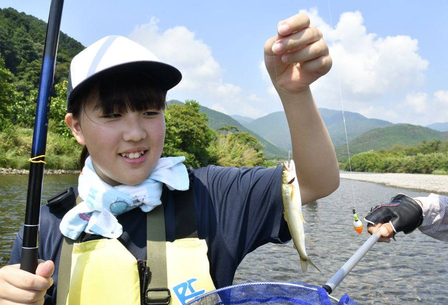 アユを釣り上げてうれしそうに掲げる野根中学校の生徒（東洋町の野根川）