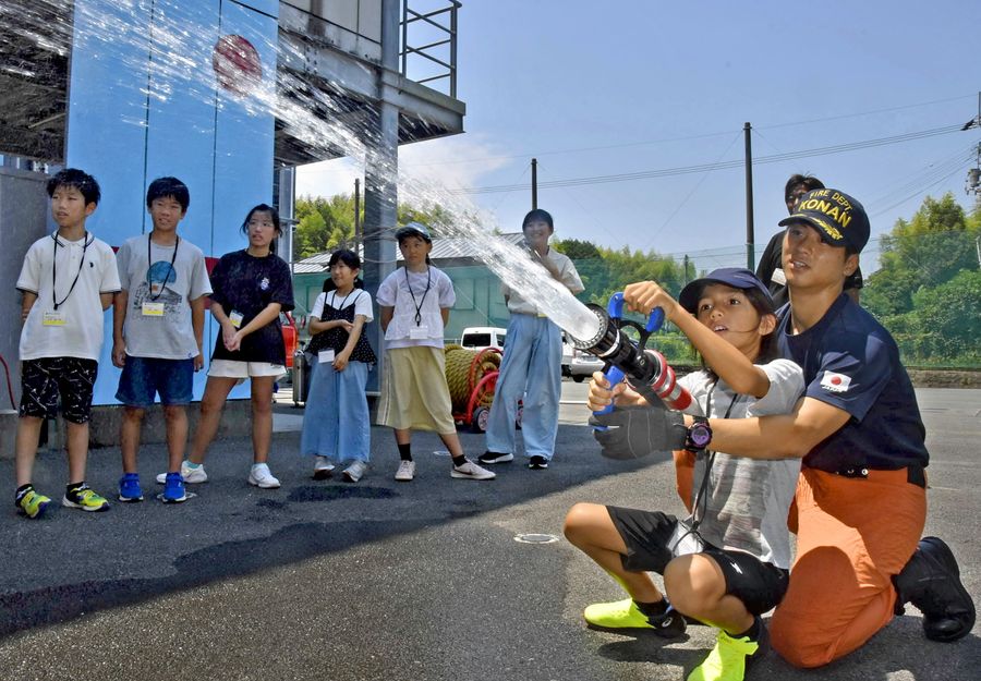 消防隊員に教わりながら放水を体験する子どもたち（香南市消防本部）