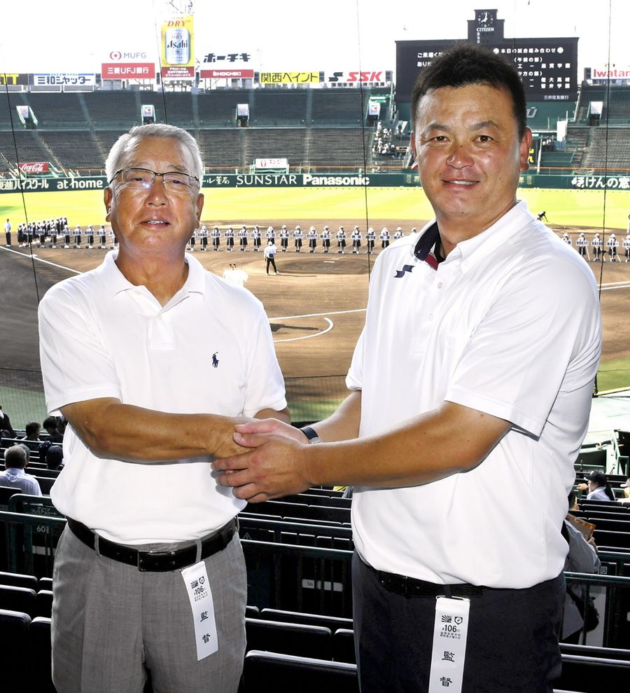 握手して健闘を誓い合う明徳義塾・馬淵史郎監督=左=と鳥取城北・大林仁監督(甲子園)