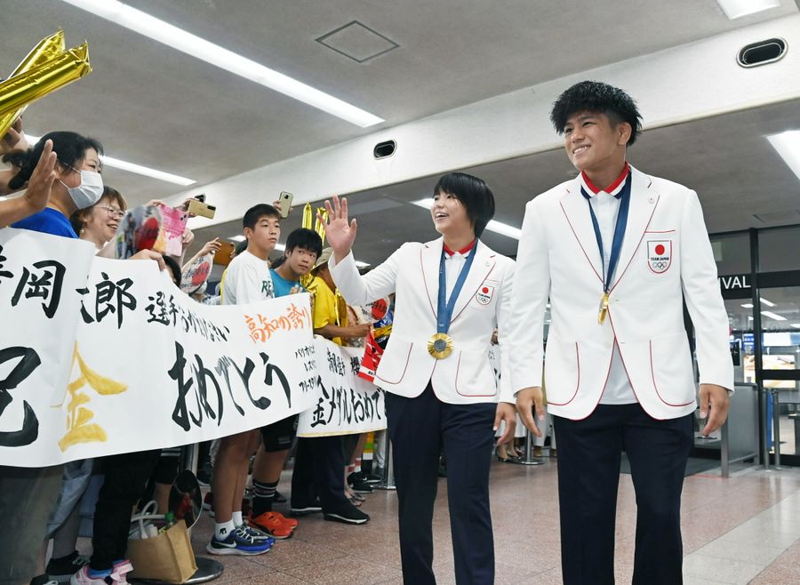 空港の到着ロビーで歓迎を受ける清岡選手＝右＝と桜井選手（南国市の高知龍馬空港＝森本敦士撮影）