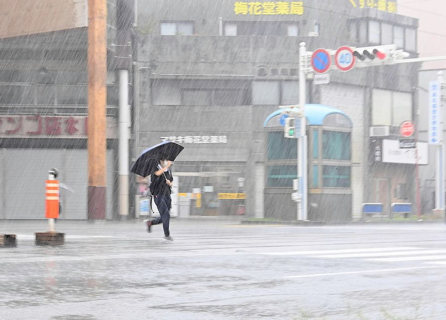 激しい雨が降ったりやんだりを繰り返した高知市内(30日午前11時55分ごろ、同市はりまや町1丁目付近)