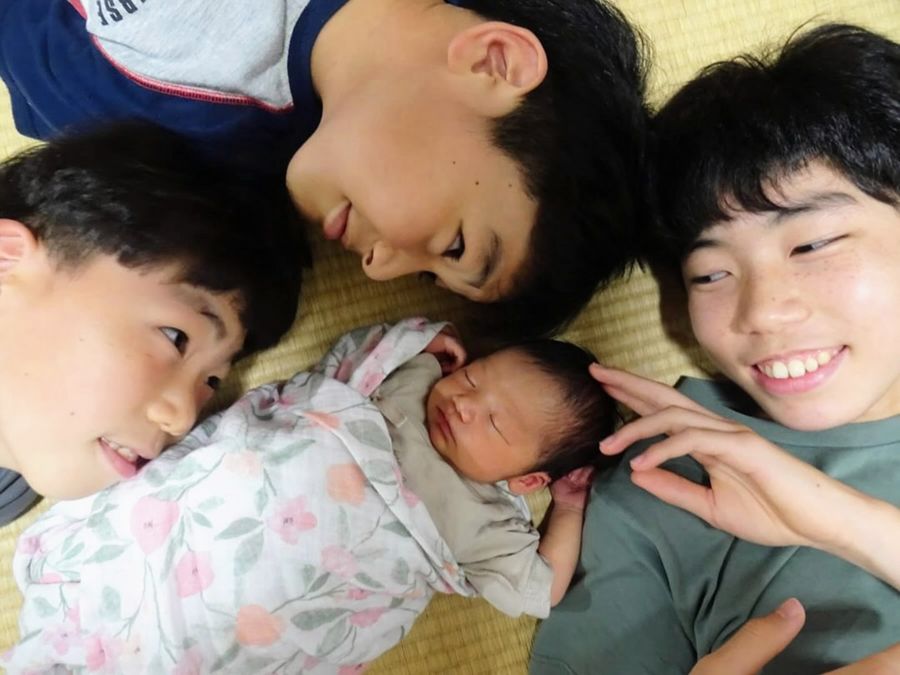 生まれたばかりの妹を兄弟で囲んだ自宅での最初の記念写真。みんな目がハートだ（２０２２年６月＝橋本さん提供）