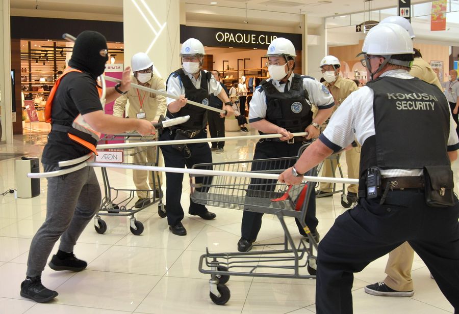 テロリスト役の男性を押さえる警備員ら(高知市のイオンモール高知)