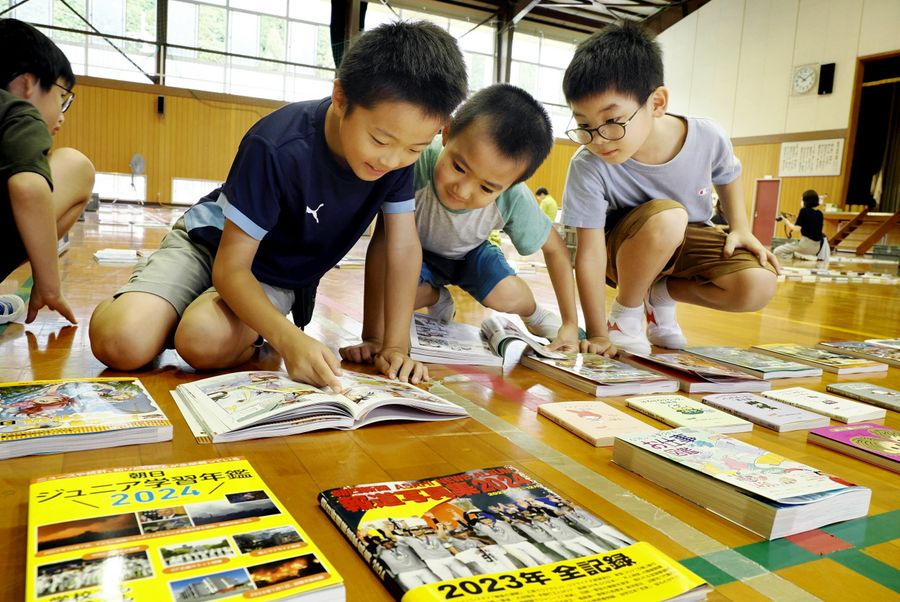 体育館いっぱいに並んだ本に夢中の子どもたち(須崎市下分甲の新荘小学校)