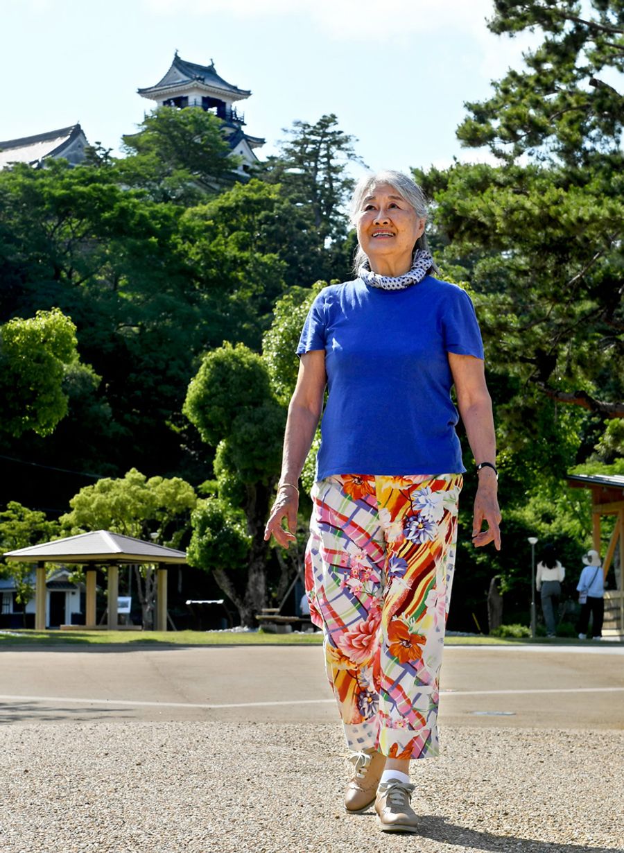 今年の初夏、高知に一時帰省した亀井昭子さん。南フランスを思わせる鮮やかな色彩の服がよく似合う（高知市の丸ノ内緑地＝加治屋隆文撮影）