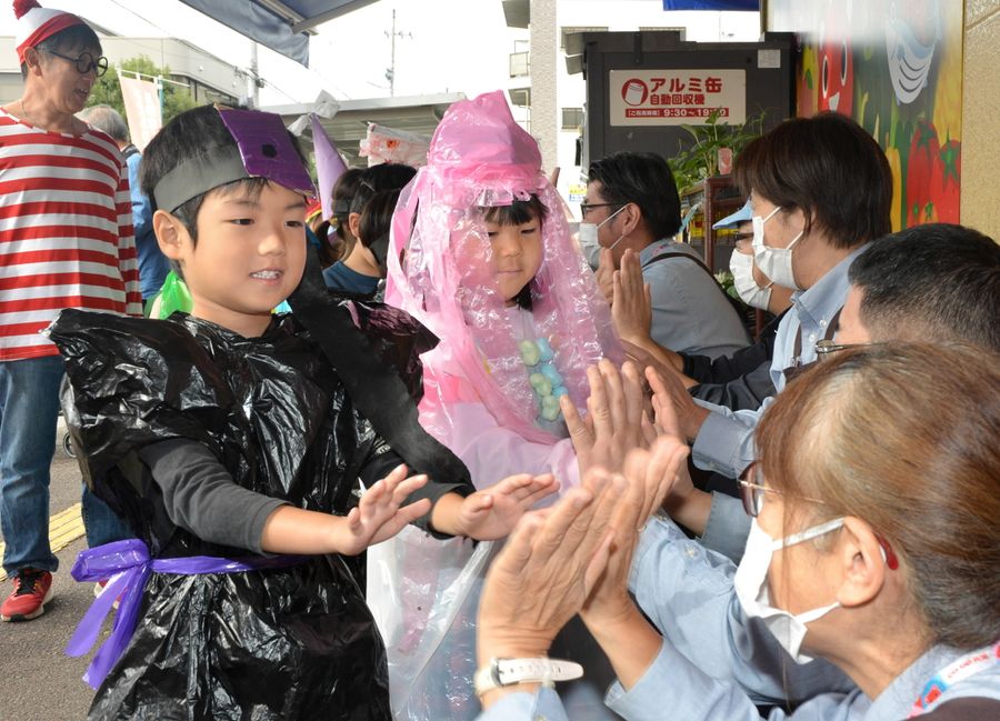 スーパーの店員とハイタッチする園児ら（高知市吉田町のコープよしだ）