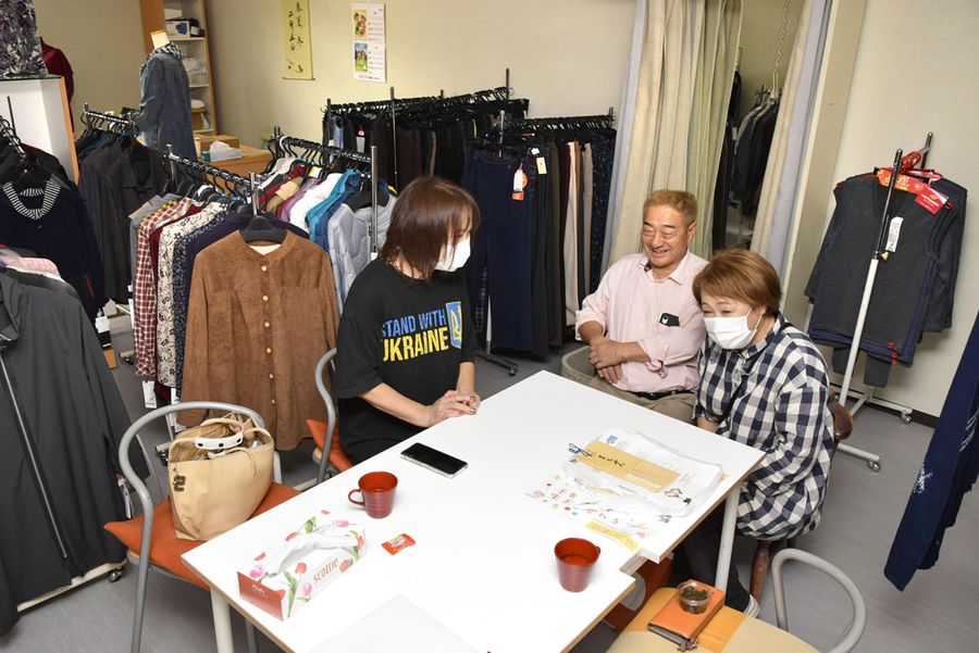 仮設店舗で世間話に花を咲かせる能村武文さん、啓子さん＝右＝夫妻と住民の女性（石川県輪島市門前町）