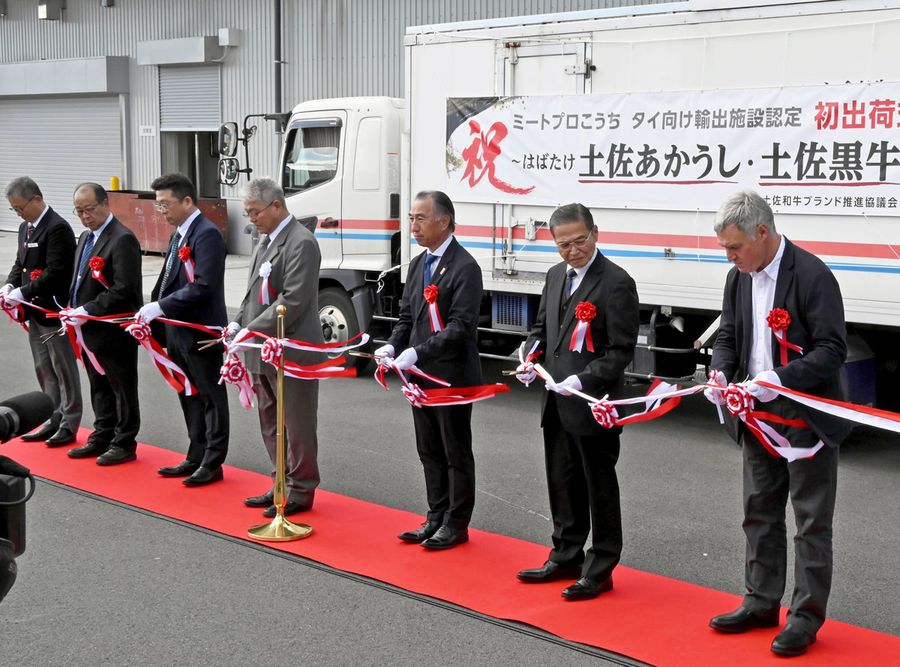 テープカットで土佐あかうしのタイ輸出を祝う畜産関係者（高知市海老ノ丸）