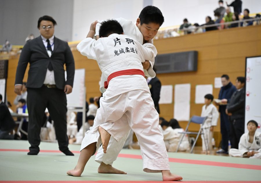 真剣な表情で組み合う子どもたち（宿毛市総合運動公園体育館）