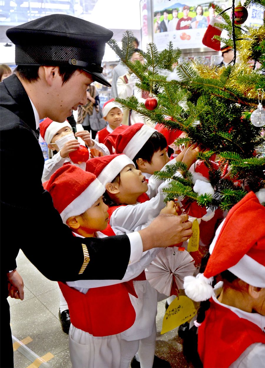 ツリーに飾り付けをする園児たち（高知市の高知駅構内）