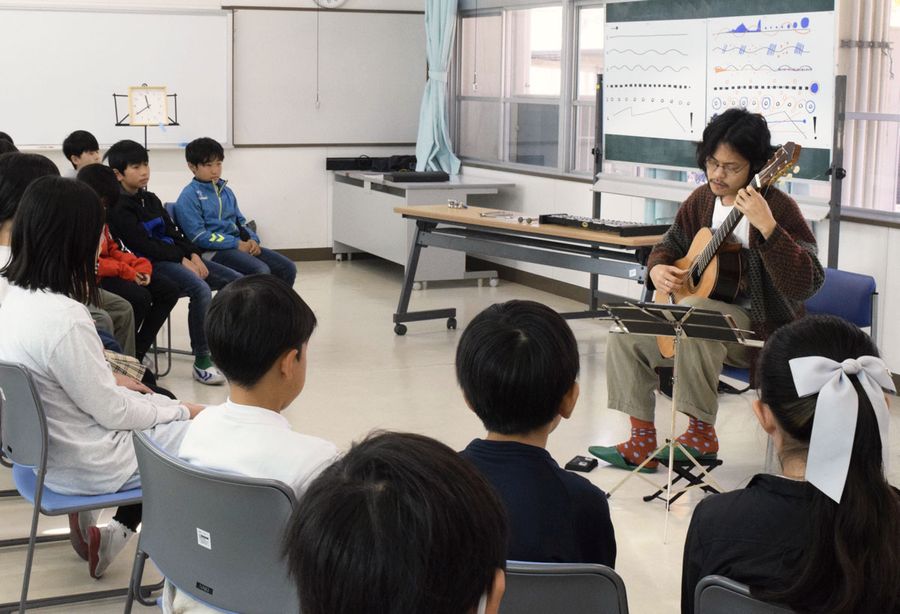 閑喜弦介さんのギター演奏に聞き入る児童（香南市の香我美小学校）