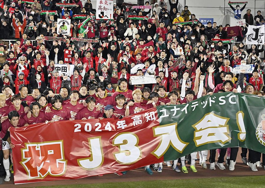 敵地での完封勝利で悲願のＪリーグ入りを決め、サポーターとともに喜びを爆発させる高知Ｕの選手たち（横浜市のニッパツ三ツ沢球技場＝新田祐也撮影）