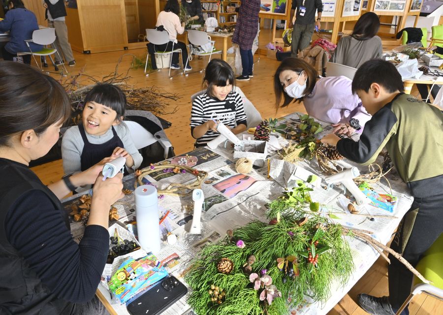 自然の素材でクリスマス飾りを作る親子連れら（土佐清水市の竜串ビジターセンター「うみのわ」）