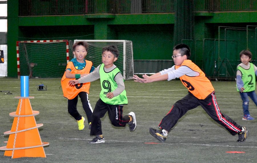 円筒形の宝を取り合う子どもたち（高知市大原町のよさこいドーム）