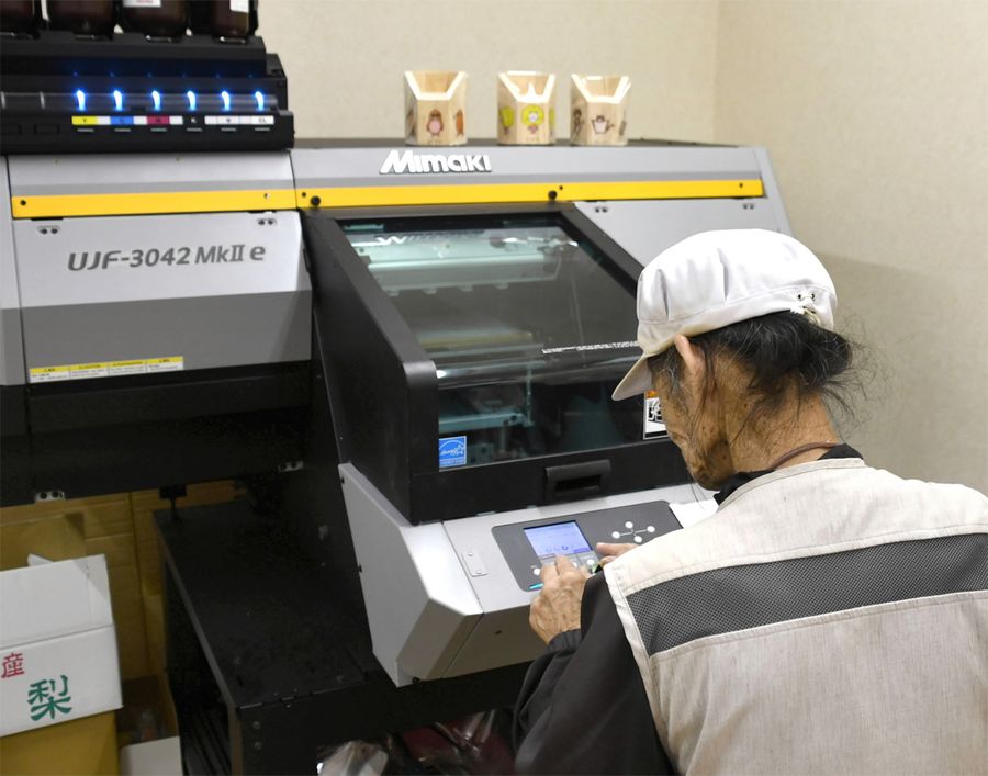 共同受注窓口で開発したキャラクターを商品に印刷する利用者(いの町の就労継続支援B型事業所「なのはな」)