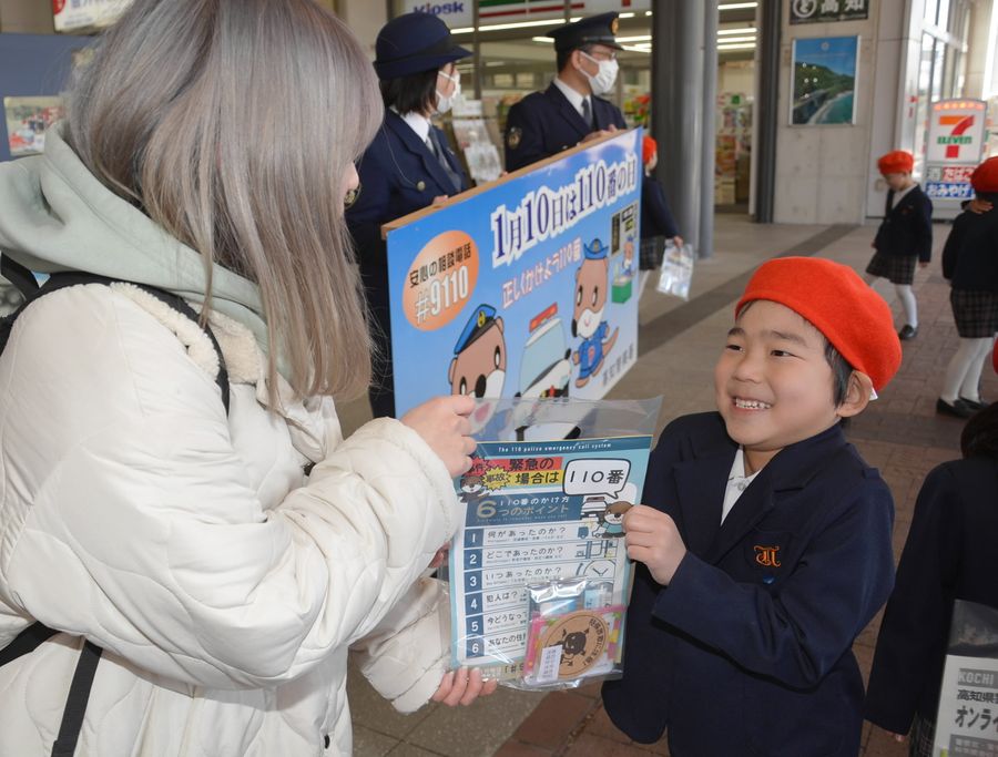 適切な１１０番通報を通行人に呼びかける園児（高知市栄田町２丁目）