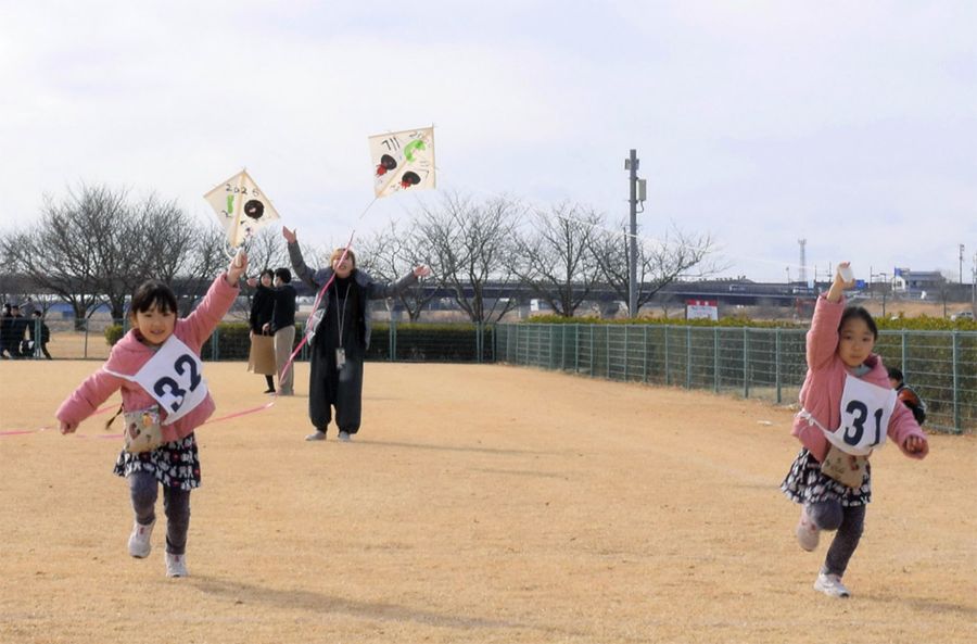 元気に走って凧を揚げる子どもたち(香南市野市町深渕)