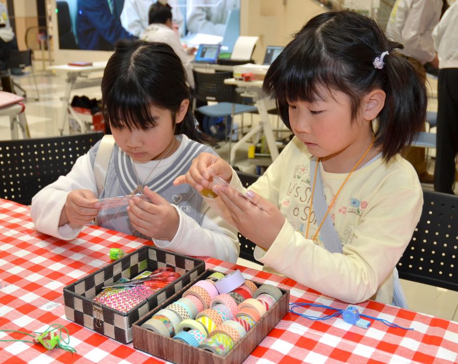 非常時に使うための笛を飾り付ける子どもたち（高知市のイオンモール高知）