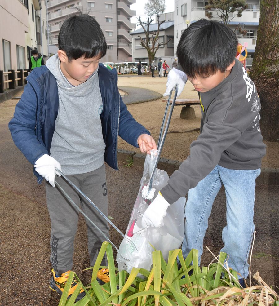 ごみを集めて回る児童（高知市の潮江東ノ丸公園）