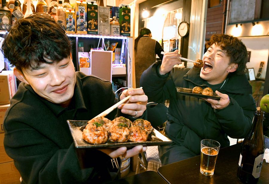 「あっつ！」。寒空とビールにぴったりのたこ焼きを味わう男性客（高知市追手筋１丁目のまるじゅう＝加治屋隆文撮影）