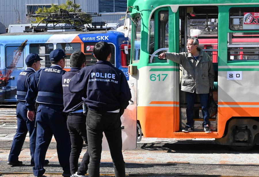 刃物を持った不審者役を制圧しようとする警察官(高知市のとさでん交通桟橋車庫)