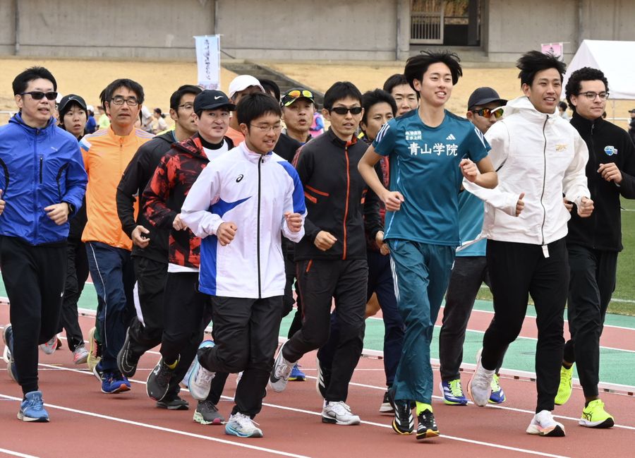 青学大の選手と一緒に走るセミナー参加者たち（高知市の春野陸上競技場）