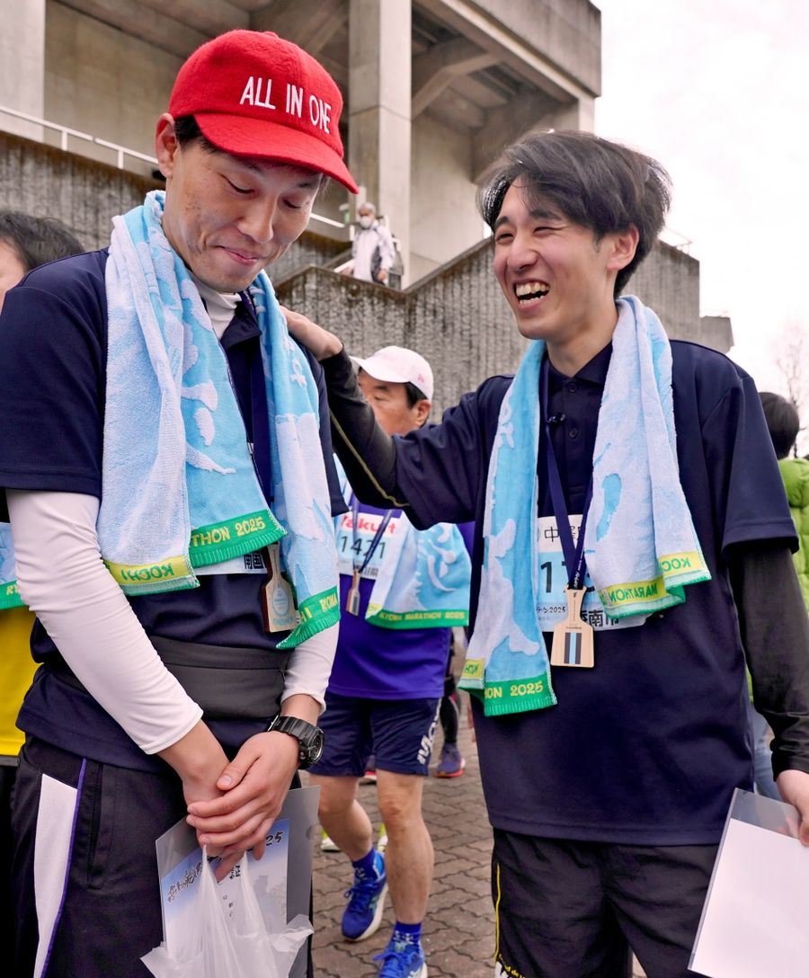 教え子の竹島一輝さん＝右＝に健闘をたたえられる坂野新太さん（高知市の春野陸上競技場）