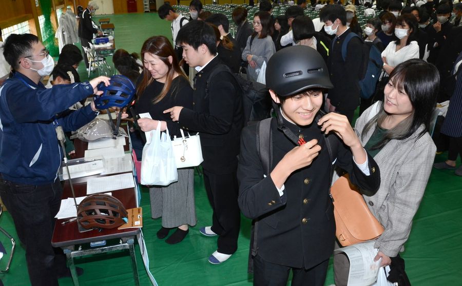 ヘルメットを試着し、予約購入する新入生ら（高知市桟橋通２丁目の高知工業高校）