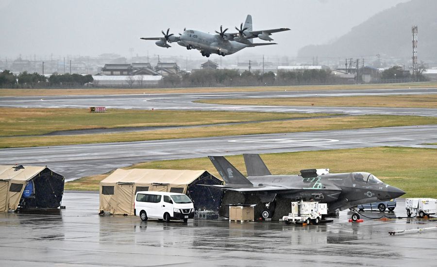 駐機したままの米軍戦闘機。後方で米軍の輸送機が飛んだ（２７日午後４時５０分ごろ、高知龍馬空港＝新田祐也撮影）