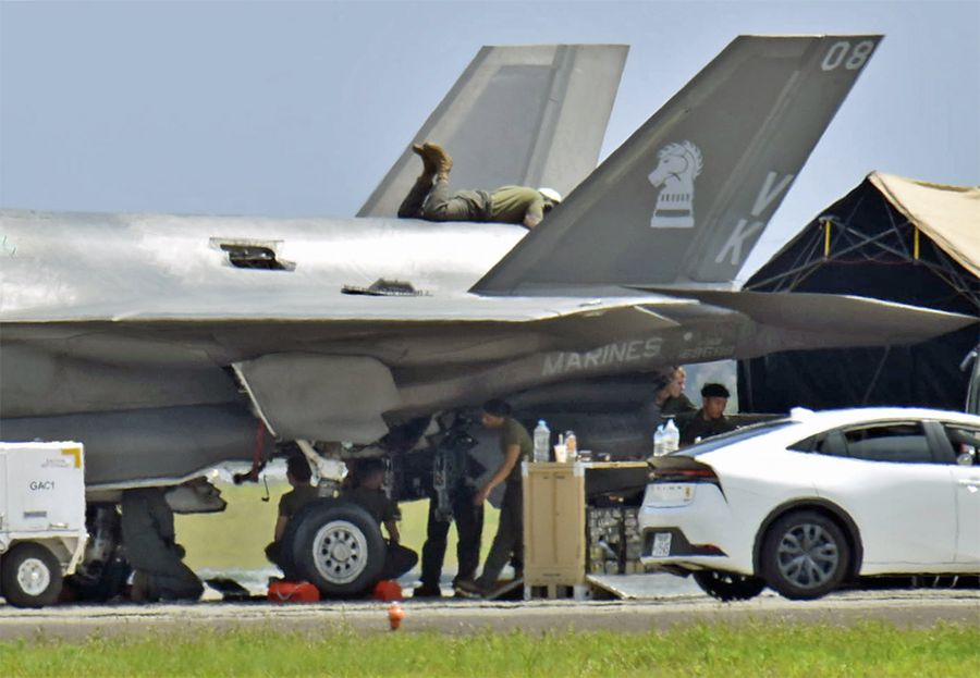 機体にエンジンを積み、整備を続ける米軍関係者（２１日午後１時ごろ、高知龍馬空港＝佐藤邦昭撮影）