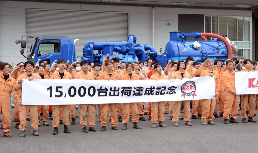 １万５千台目の製品出荷を迎え、記念撮影する兼松エンジニアリングの社員ら（高知市一宮）