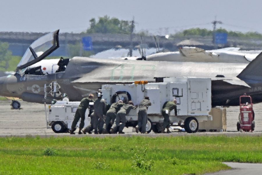 電源車のような物を押して運ぶ米軍関係者(24日午前11時半ごろ、高知龍馬空港=佐藤邦昭撮影)