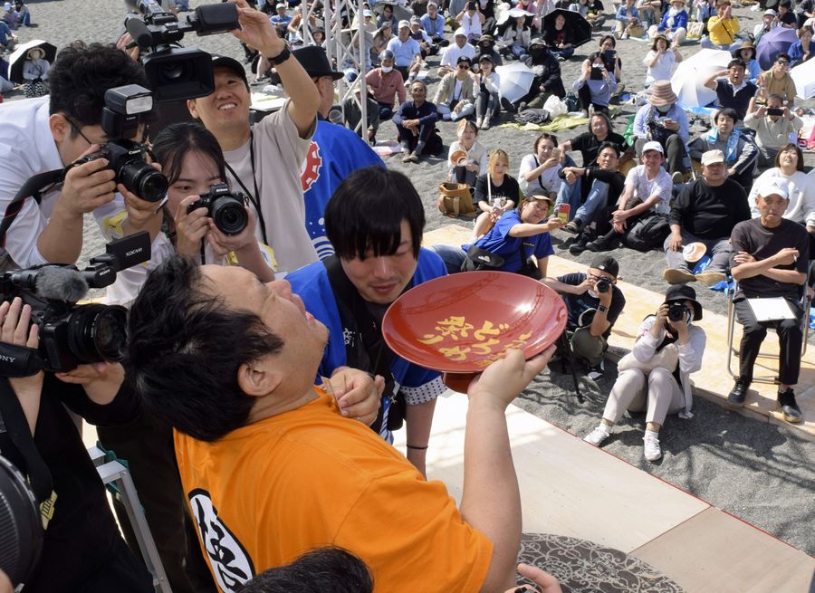 大杯の日本酒を豪快に流し込んだ「土佐赤岡どろめ祭り」（香南市の赤岡海浜）