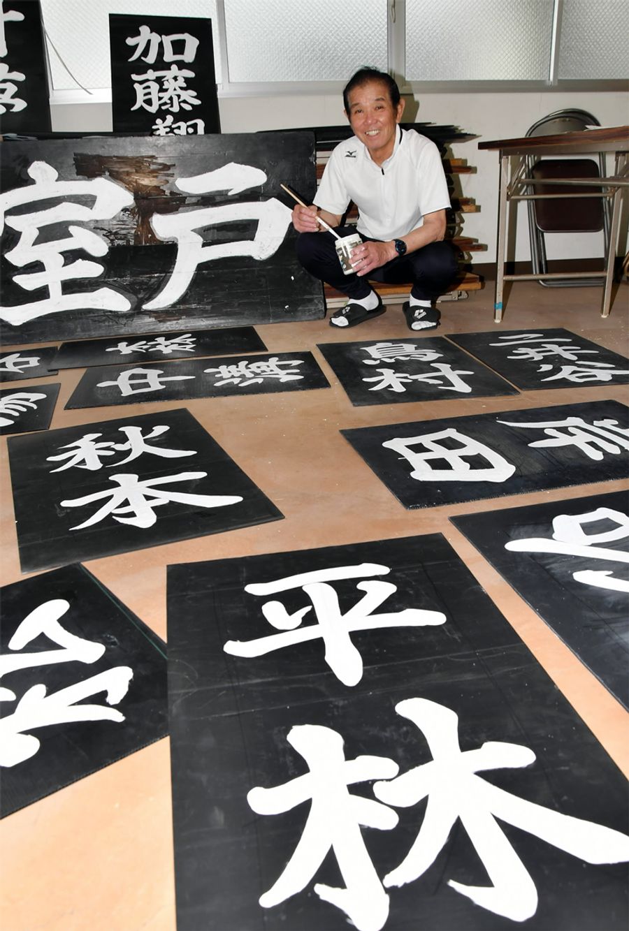 美しい文字で選手の名前を手書きしている亀井司郎さん。約５０人分を３日で仕上げる（室戸市領家の県室戸広域公園野球場）