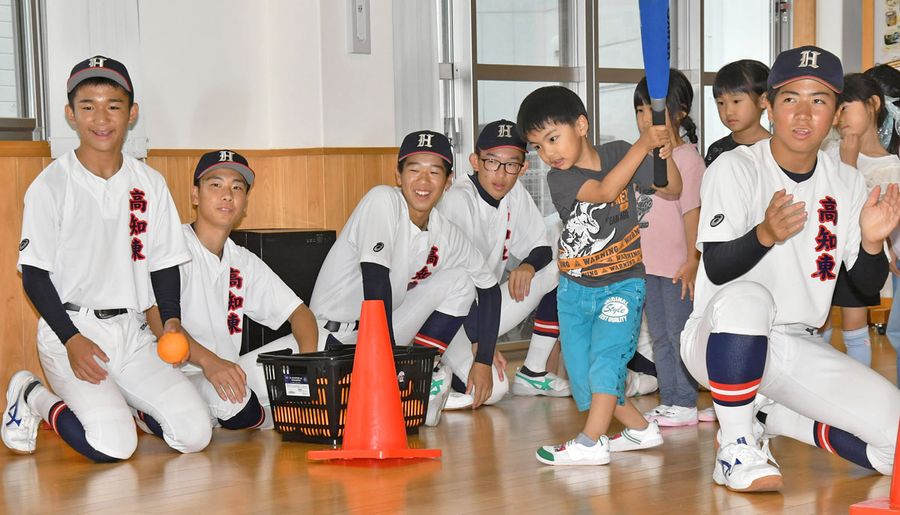 フルスイングの園児に「ナイバッチ！」と声をかける高知東高野球部員たち（高知市一宮中町１丁目のあおい保育園）