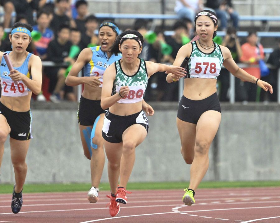 【女子４００メートルリレー決勝】県高校記録を更新する４６秒３２で優勝した高知農。３走・岡林結衣＝右端＝からアンカー横山穂乃翔にバトンが渡る（愛媛ニンジニアスタジアム）