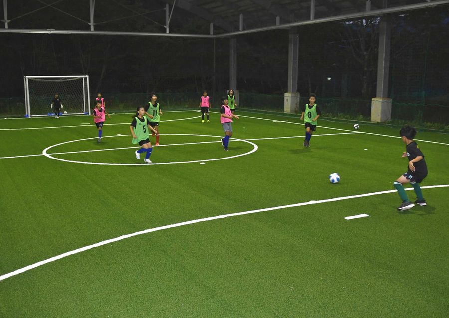 新設されたフットサル場でボールを追いかけて楽しむ地元小学生（日高村本郷の村総合運動公園）