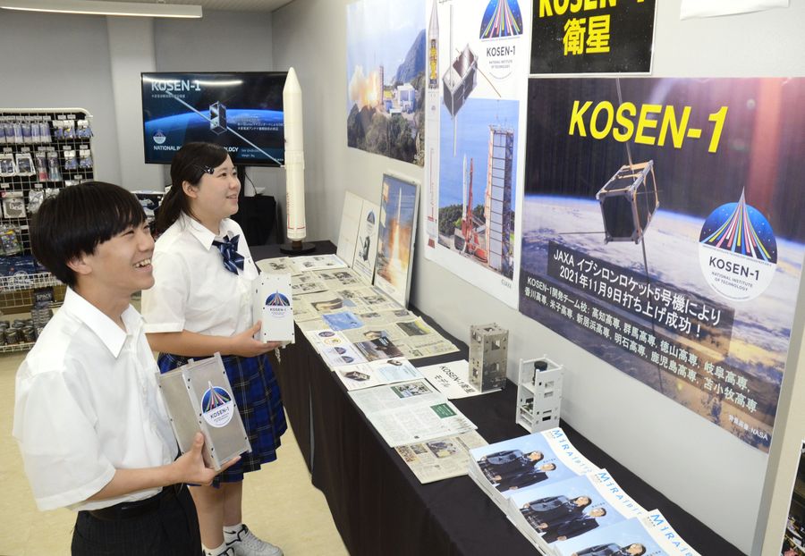 「KOSEN―１」の実寸大の模型を手に展示を紹介する高知高専の学生（南国市の海洋堂SpaceFactoryなんこく）