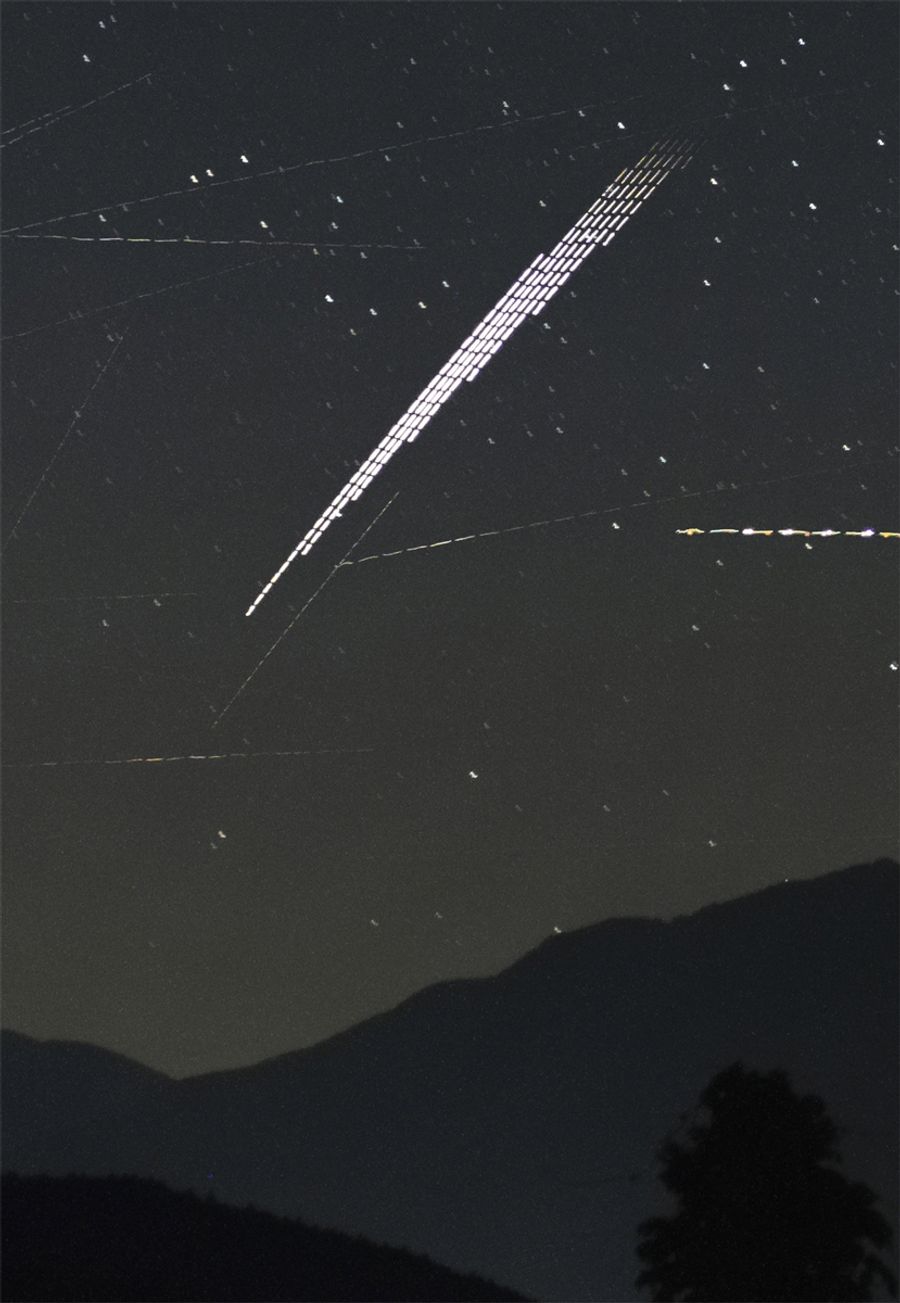 「スターリンク」衛星の光跡。周囲の細い光は他の人工衛星や飛行機（６月２８日夜、中島健蔵さん撮影）
