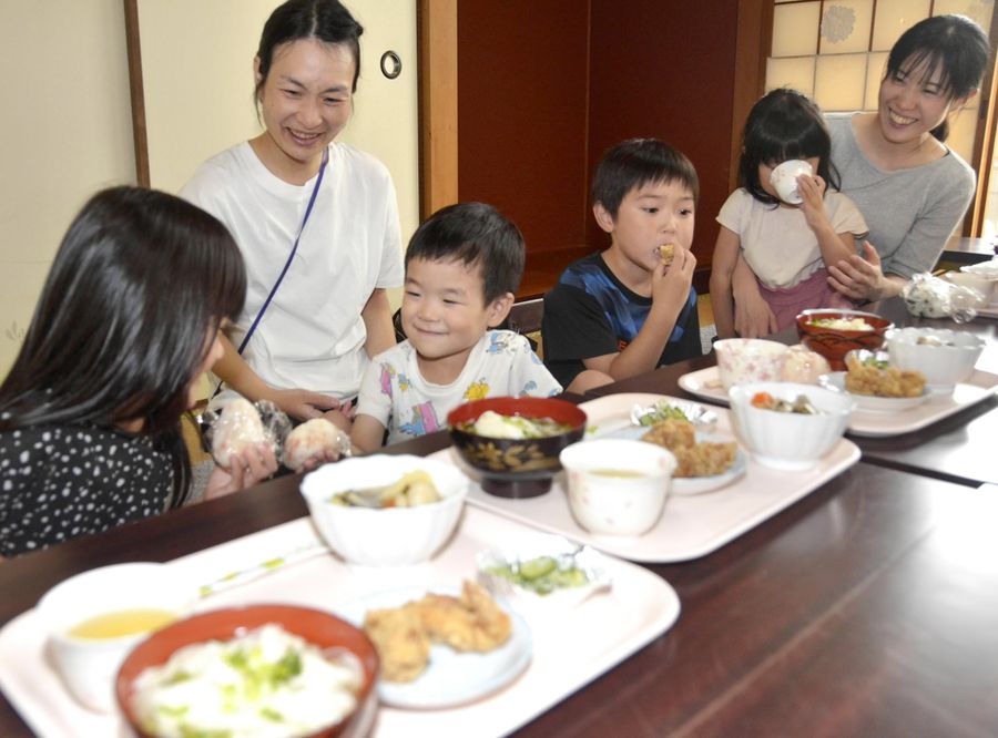 提供されたおにぎりや唐揚げなどを頬張る町民（東洋町野根丙の町文化会館）