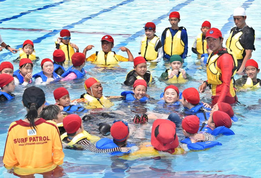 着衣のまま輪になって救助を待つ訓練をした児童ら（高知市鴨部の鴨田小）