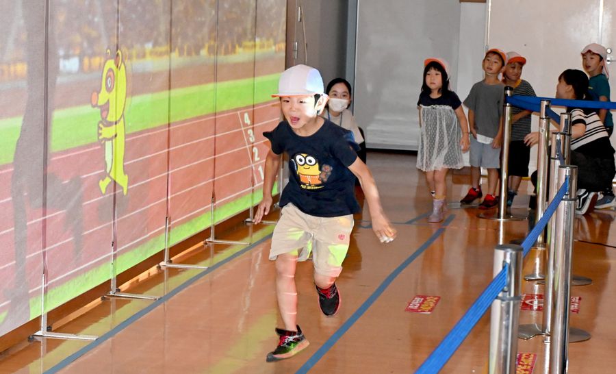 「スーパー１０メートル走」でキャラクターと競走する園児（高知市秦南町１丁目のイオンモール高知）