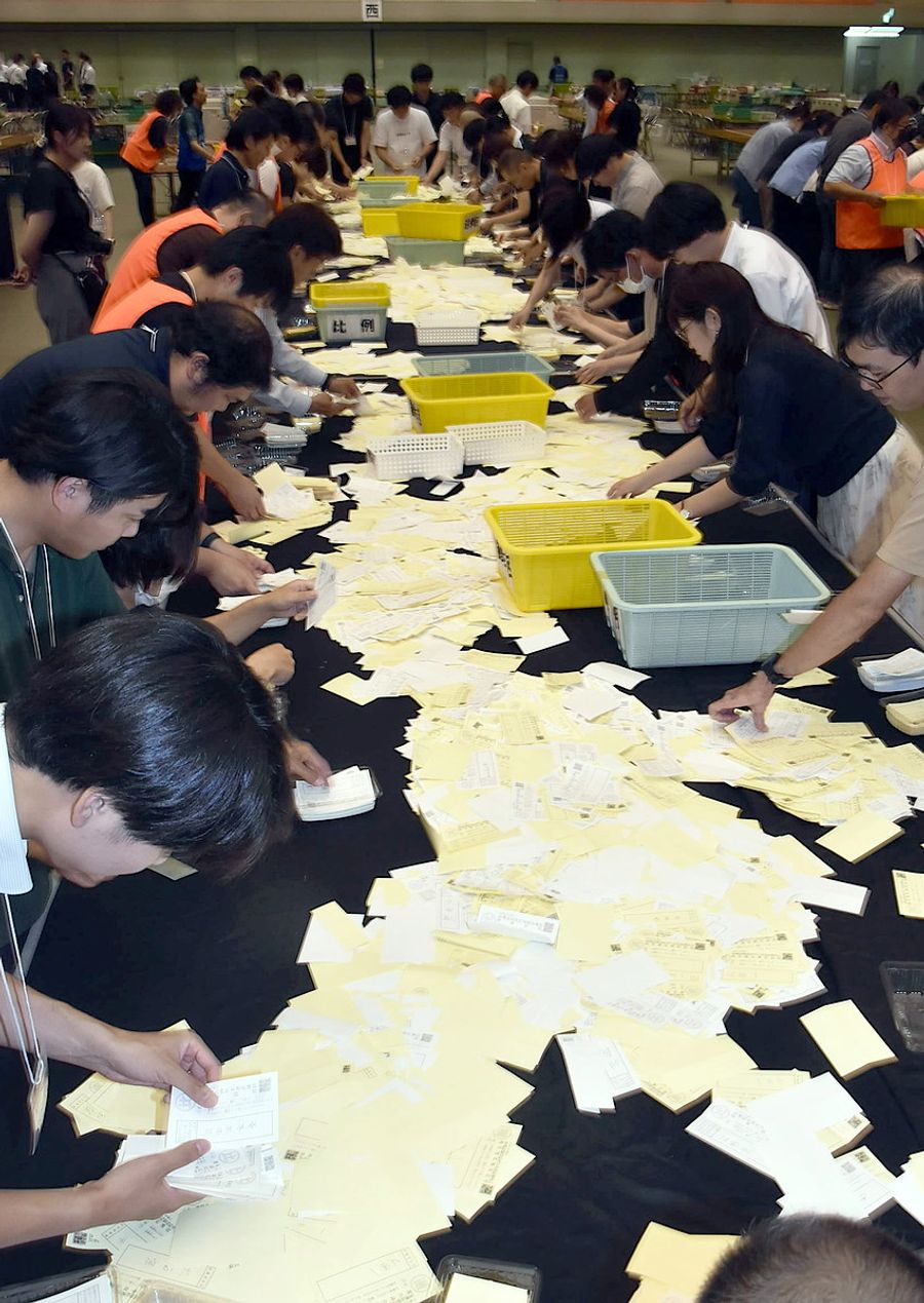 開票台に広げられた票。一枚一枚に県民の期待が込められた（２０日夜、高知市の春野体育館）