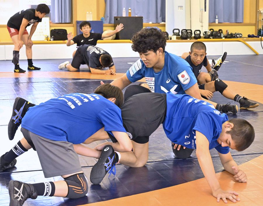 後輩に技術を伝える西内悠人＝前方中央。パリ五輪金メダリストの樋口黎＝後方で左手を上げている＝も指導に当たった（高知市の高知東高）