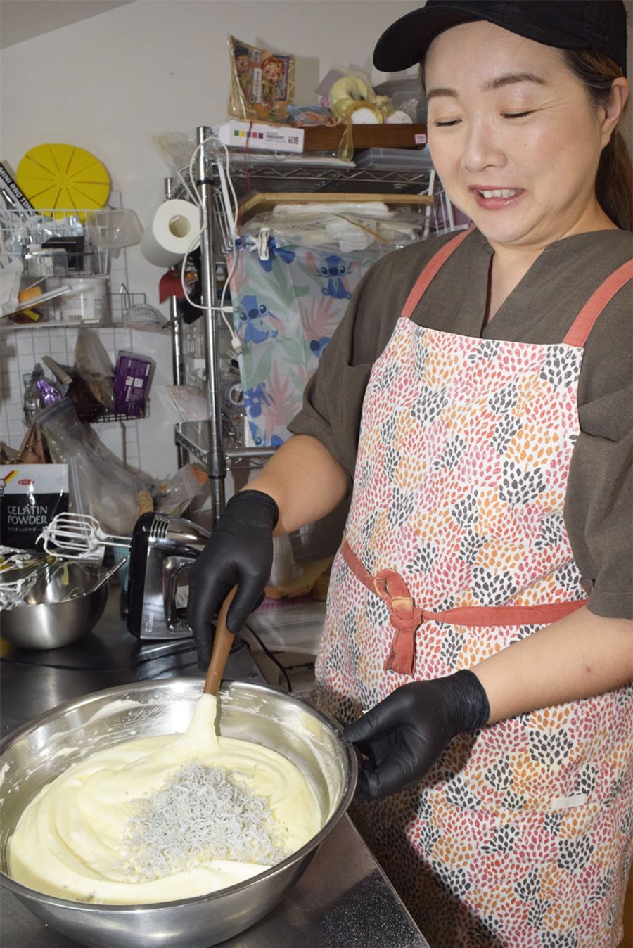 じゃこを生地に投入する西内真菜さん。「作りながらも目が合うんですよ。じゃこと」　