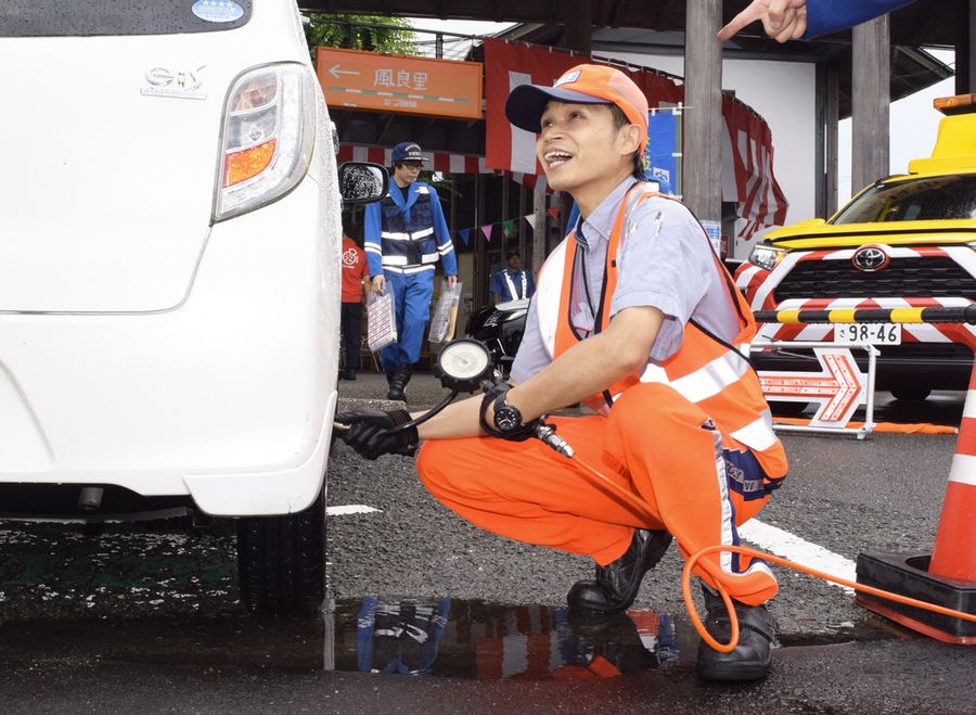 車のタイヤの空気圧を点検するＪＡＦ高知支部のスタッフ（南国市の「道の駅南国　風良里」）
