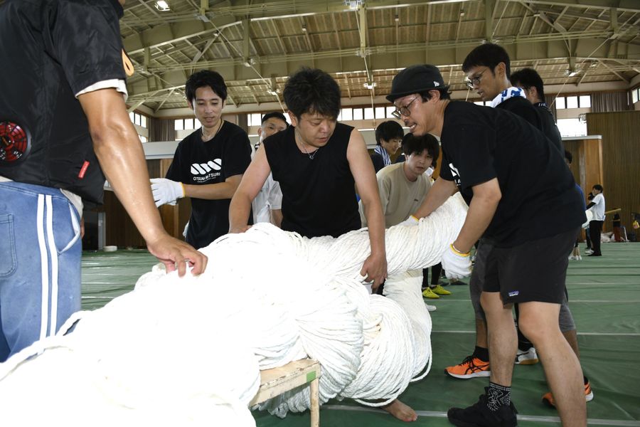 土佐市商工会青年部員らが力を合わせて大綱を編み上げた（土佐市民体育館）