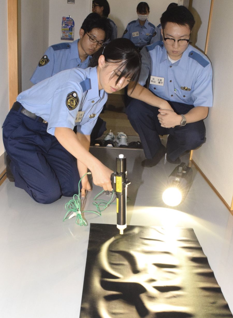 犯人の足跡を採取して鑑識捜査を体験する参加者（南国署）