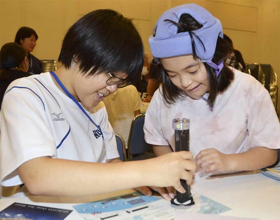 ボランティアの室戸高生と万華鏡作りを楽しむ子ども（室戸市の市保健福祉センターやすらぎ）